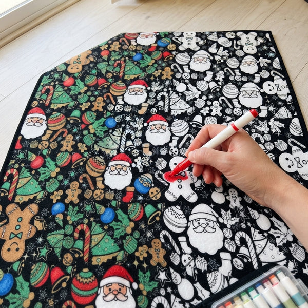 A close-up view of a hand coloring intricate line patterns on a fabric blanket with a marker.